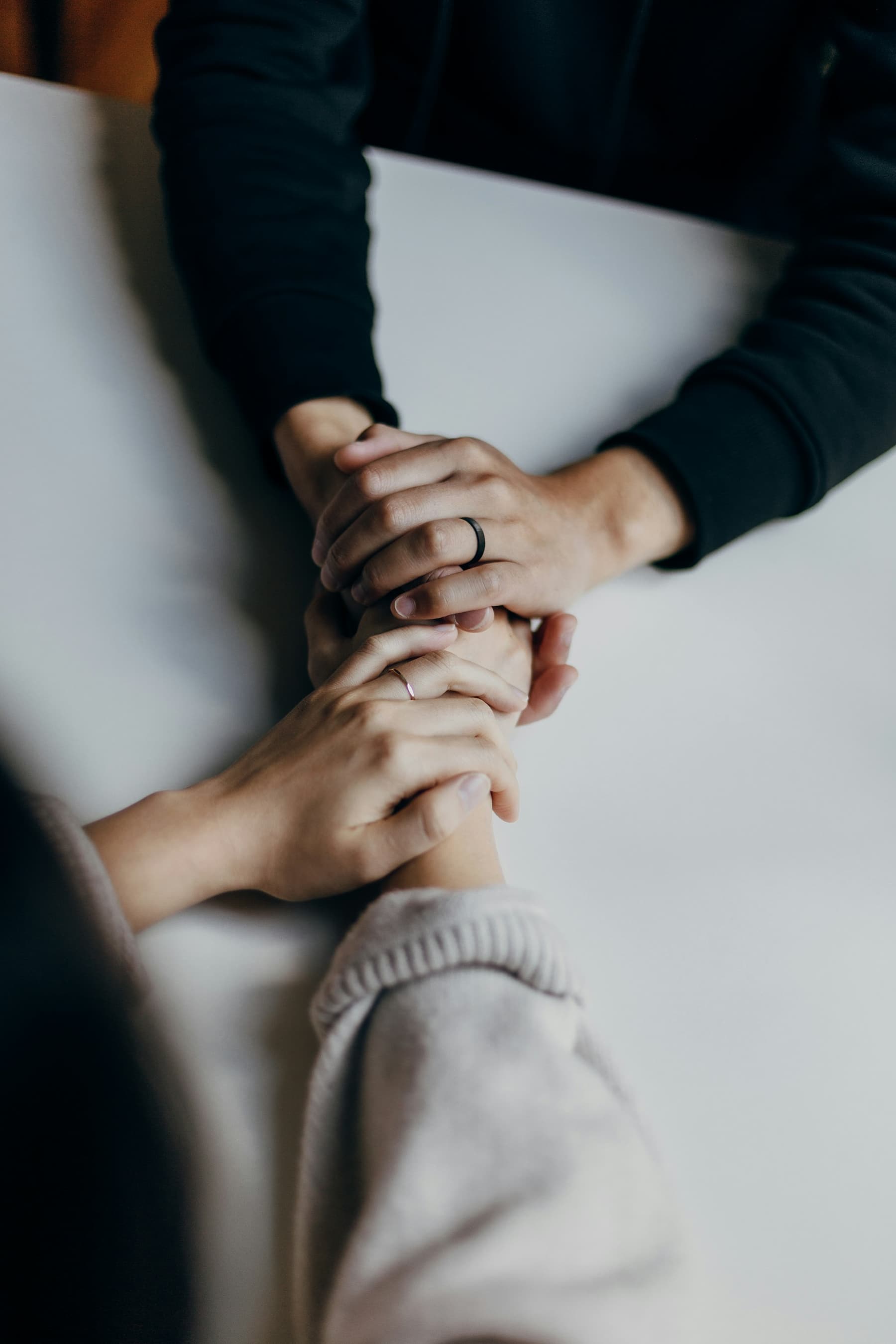 Two people’s hands held together on a table