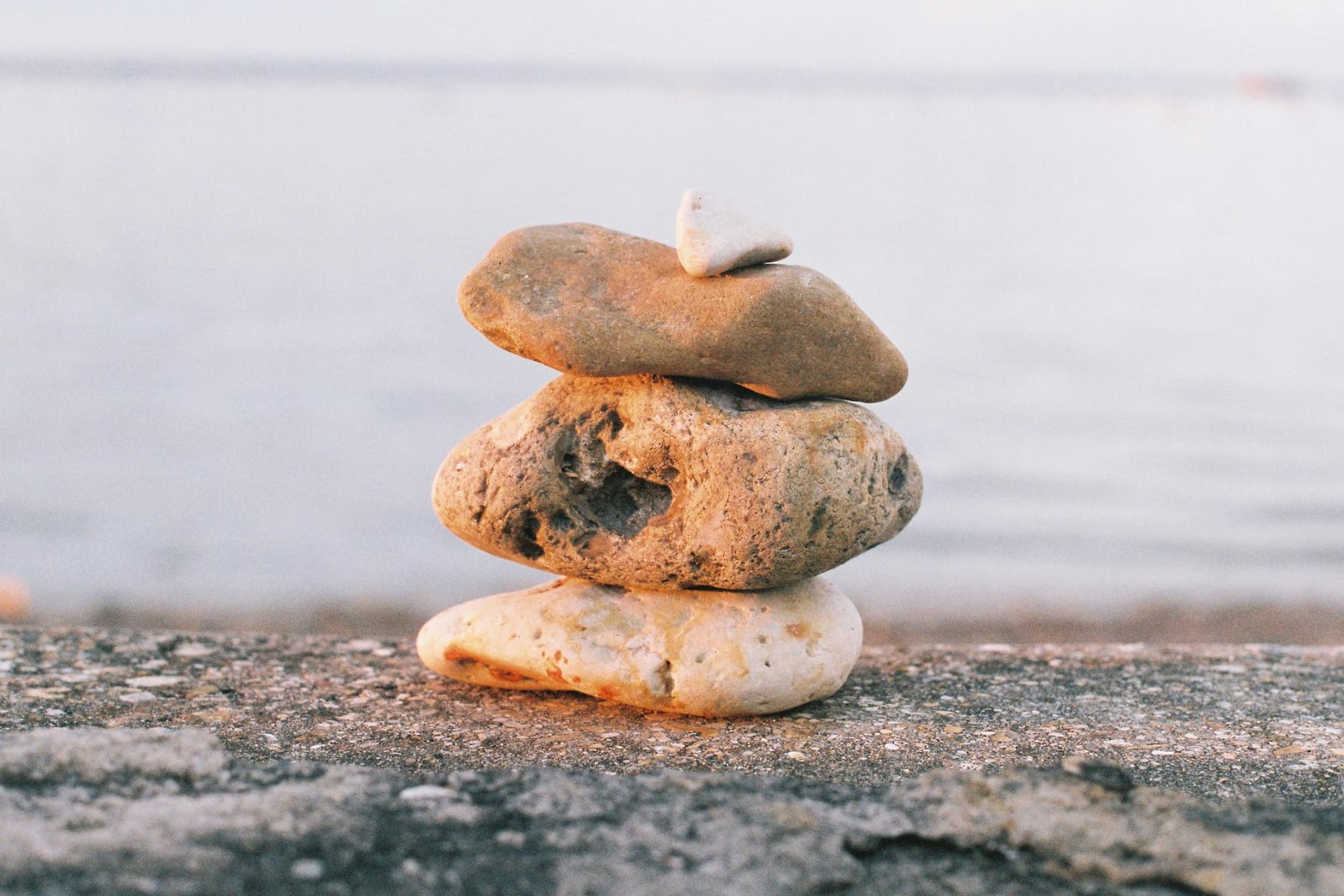 Three stones balanced in a stack by the water